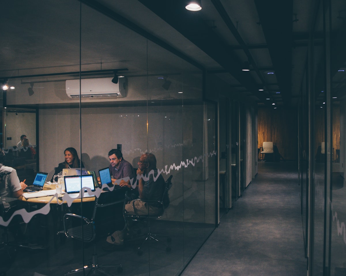Glass-walled conference room with an advisory team in discussion